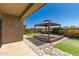 Backyard featuring a gazebo with a wooden deck, desert landscaping, and stone accents at 303 W Mammoth Cave Dr, San Tan Valley, AZ 85140
