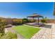 Backyard showcasing a gazebo with a wooden deck, artificial grass, and desert landscaping at 303 W Mammoth Cave Dr, San Tan Valley, AZ 85140
