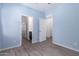 Bedroom boasts light blue walls, wood floors, and open doorways to other rooms at 303 W Mammoth Cave Dr, San Tan Valley, AZ 85140