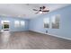 Bright and airy living room features wood-look floors, large windows, and a ceiling fan at 303 W Mammoth Cave Dr, San Tan Valley, AZ 85140