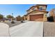 Two-story house with tan exterior, two-car garage, and desert landscaping at 6802 N 86Th Ln, Glendale, AZ 85305