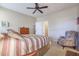 Spacious bedroom with striped bedding and ceiling fan at 17547 W Silver Fox Way, Goodyear, AZ 85338