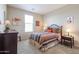 Bedroom with striped bedding and dark wood furniture at 17547 W Silver Fox Way, Goodyear, AZ 85338