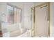 Bright bathroom features a bathtub with a window and a glass-enclosed shower with a gold frame at 3055 N Red Mountain Mtn # 95, Mesa, AZ 85207