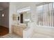 Bathroom with a double sink vanity, large window, and a relaxing bathtub at 3055 N Red Mountain Mtn # 95, Mesa, AZ 85207