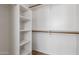 An organized walk-in closet with built-in shelves and wooden rods for ample storage at 3055 N Red Mountain Mtn # 95, Mesa, AZ 85207