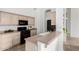 Well-lit kitchen with black appliances, neutral countertops, and pass-through to the dining area at 3055 N Red Mountain Mtn # 95, Mesa, AZ 85207