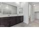 Bright bathroom features a double sink vanity with quartz countertop, mirrors, and a glass door shower at 31465 N Wet Creek Rd, San Tan Valley, AZ 85143