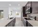 Modern kitchen with stainless steel appliances, quartz countertops and dark wood cabinets at 31465 N Wet Creek Rd, San Tan Valley, AZ 85143