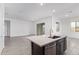 Open-concept kitchen showcases a kitchen island with stainless steel appliances and access to an outdoor patio at 31465 N Wet Creek Rd, San Tan Valley, AZ 85143