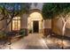 Inviting entryway with stone walkway, lush landscaping, and a charming arched entry at 41348 N Congressional Dr, Anthem, AZ 85086
