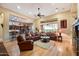 Open living room with leather furniture, hardwood floors, and a fireplace at 41348 N Congressional Dr, Anthem, AZ 85086