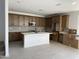 Modern kitchen with wood cabinets, white island, and tile backsplash at 4931 W Beryl Ave, Glendale, AZ 85302