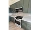 Stylish kitchen boasting dark green cabinets, quartz countertops, and a built-in microwave at 6891 W Via Del Sol Dr, Glendale, AZ 85310