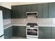 Stylish kitchen with dark green cabinets and a built-in microwave at 6891 W Via Del Sol Dr, Glendale, AZ 85310