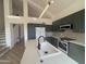 Contemporary kitchen with white quartz countertops and dark green cabinets at 6891 W Via Del Sol Dr, Glendale, AZ 85310