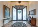 Elegant foyer with decorative rug, art, and frosted-glass door with wrought iron detailing and high ceilings at 10742 E Greythorn Dr, Scottsdale, AZ 85262