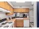Kitchen with wood cabinets, white appliances, and a view to living room at 170 E Guadalupe Rd # 14, Gilbert, AZ 85234