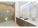 Bathroom featuring a dual sink vanity with wood cabinets, modern fixtures, and a glass enclosed shower at 30500 N 208Th Dr, Wittmann, AZ 85361