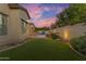 Landscaped backyard oasis with putting green, pool, and outdoor kitchen at 501 E Sunburst Ln, Tempe, AZ 85284