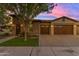 Single story home with stone and stucco exterior, wood garage doors, and manicured lawn at 501 E Sunburst Ln, Tempe, AZ 85284