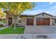 Luxury home exterior with stone accents and a wooden garage door at 501 E Sunburst Ln, Tempe, AZ 85284