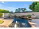 Inviting swimming pool with waterfall feature and spacious patio at 501 E Sunburst Ln, Tempe, AZ 85284