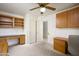 Bedroom with ceiling fan, cabinets, desk, and chair with neutral carpet at 11250 E Kilarea Ave # 252, Mesa, AZ 85209
