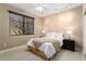 Relaxing bedroom featuring a queen bed, soft lighting, and a large window with wood blinds at 19814 N Shadow Mountain Dr, Surprise, AZ 85374