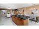 Open kitchen with a large island, dark countertops, and a view of the living room at 19814 N Shadow Mountain Dr, Surprise, AZ 85374
