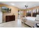 Comfortable main bedroom featuring natural light, ensuite access, and ceiling fan at 19814 N Shadow Mountain Dr, Surprise, AZ 85374