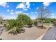 A well-maintained backyard with desert landscaping and a brick-paved walkway leading from the patio at 26822 W Oraibi Dr, Buckeye, AZ 85396
