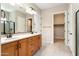 Bathroom featuring double sinks, wood cabinets, and a walk-in shower at 26822 W Oraibi Dr, Buckeye, AZ 85396