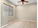 Bright bedroom with neutral walls, tile floors, a ceiling fan, and a window for natural light at 26822 W Oraibi Dr, Buckeye, AZ 85396