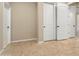 Hallway with tile floors, multiple doors, and neutral colored walls at 26822 W Oraibi Dr, Buckeye, AZ 85396