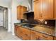 Well-equipped kitchen with wooden cabinets, granite countertops, and a modern vent hood at 26822 W Oraibi Dr, Buckeye, AZ 85396