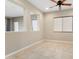 Open-concept room with neutral walls, tile floors, multiple windows, and an inviting living space at 26822 W Oraibi Dr, Buckeye, AZ 85396