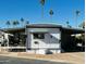 Mobile home exterior with covered patio and desert landscaping at 4065 E University Dr # 140, Mesa, AZ 85205