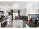 Modern kitchen features white cabinets, dark countertops, and a breakfast bar at 8813 N 112Th Ave, Peoria, AZ 85345