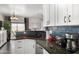 Modern kitchen with white cabinets, dark countertops, and breakfast bar at 8813 N 112Th Ave, Peoria, AZ 85345