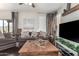 Living room with gray sofa, wooden coffee table, and large TV at 8813 N 112Th Ave, Peoria, AZ 85345