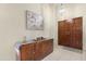 Foyer featuring a modern light fixture, a wooden double door and decorative cabinet at 10309 E Twilight Ct, Sun Lakes, AZ 85248