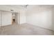 Open bedroom featuring neutral carpet, large window with palm tree views, and ensuite bathroom access at 17 W Vernon Ave # 316, Phoenix, AZ 85003