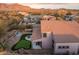 Aerial view of house showcasing backyard oasis, putting green, and mountain views at 6960 E Hacienda La Noria Ln, Gold Canyon, AZ 85118