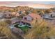 Aerial view of house with a large backyard, putting green and spa at 6960 E Hacienda La Noria Ln, Gold Canyon, AZ 85118
