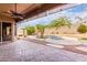 Covered patio overlooks a kidney shaped pool with a waterfall feature at 9354 E Hillview Cir, Mesa, AZ 85207