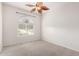 Well-lit bedroom featuring a ceiling fan and an arched window at 9354 E Hillview Cir, Mesa, AZ 85207