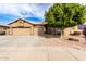 Tan two-story house with a three-car garage and nicely landscaped front yard at 9354 E Hillview Cir, Mesa, AZ 85207
