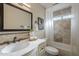 This bathroom has a single sink vanity, tub and shower with decorative tile, and a framed mirror at 11085 E Becker E Ln, Scottsdale, AZ 85259
