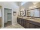 This spacious bathroom features a double sink vanity, an arched window and tile floors at 11085 E Becker E Ln, Scottsdale, AZ 85259